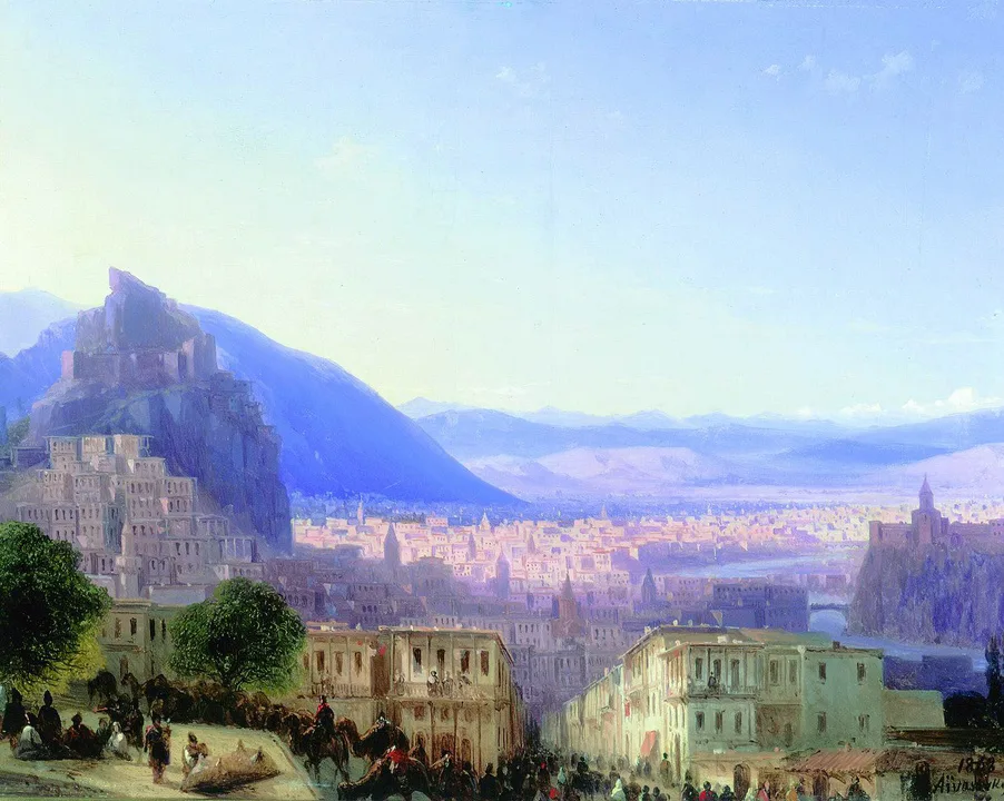 A Romantic cityscape opening onto mountains in pale evening light.