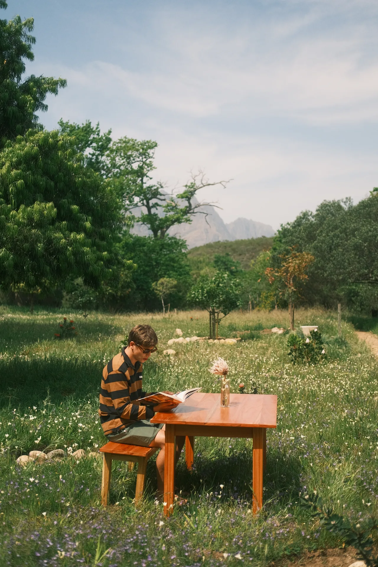 A person playing a small piano in a green garden.