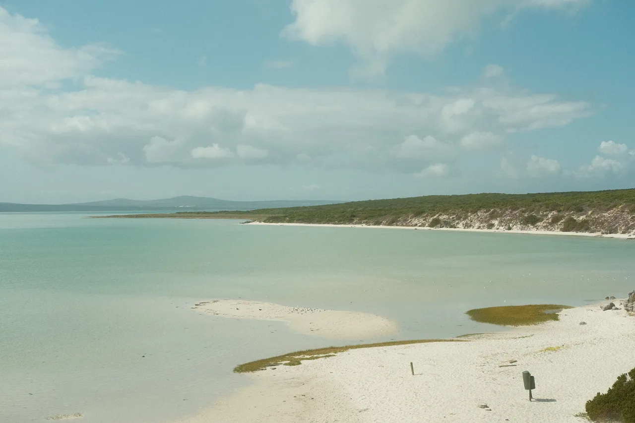 Pale sandbanks and turquoise water across a quiet coastal lagoon.
