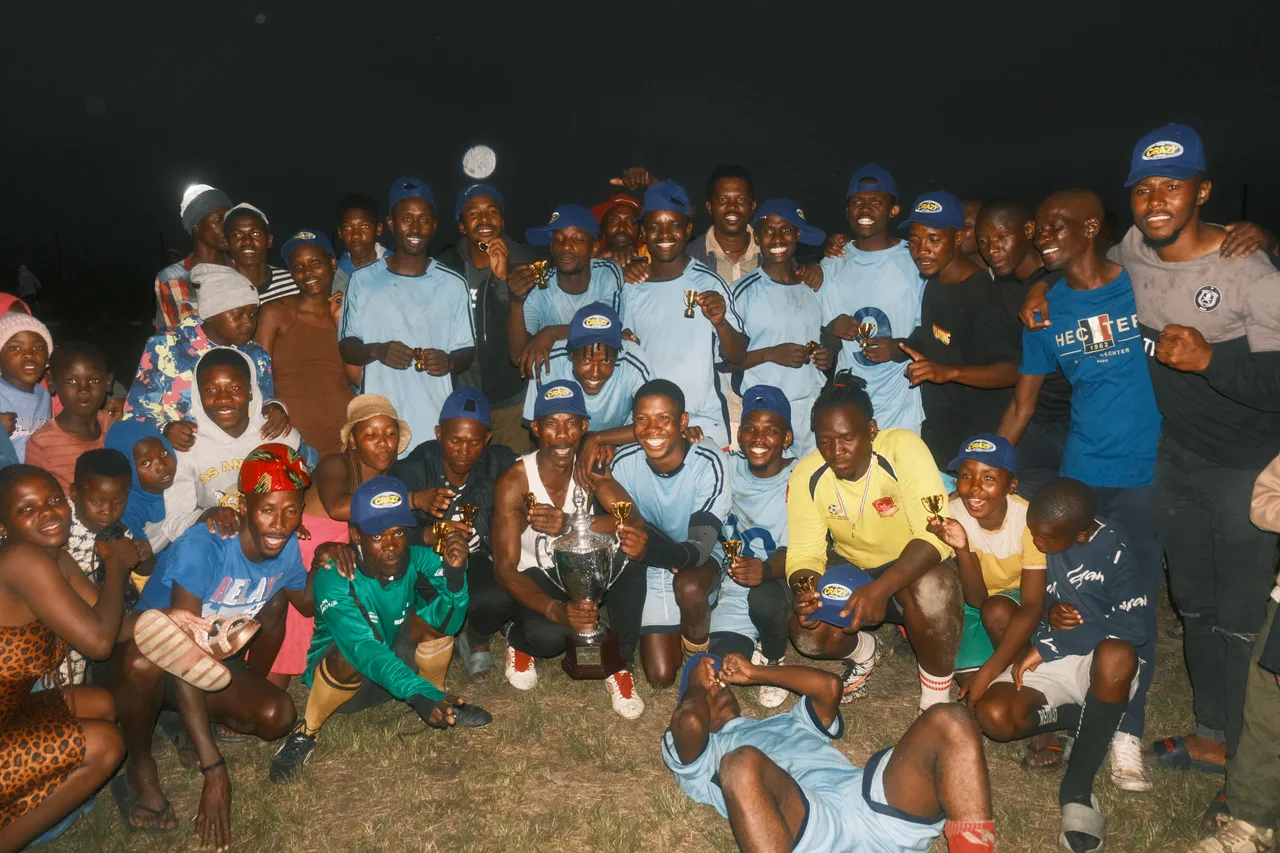 The tournament winners and Morgan Bay community celebrating with the cup.
